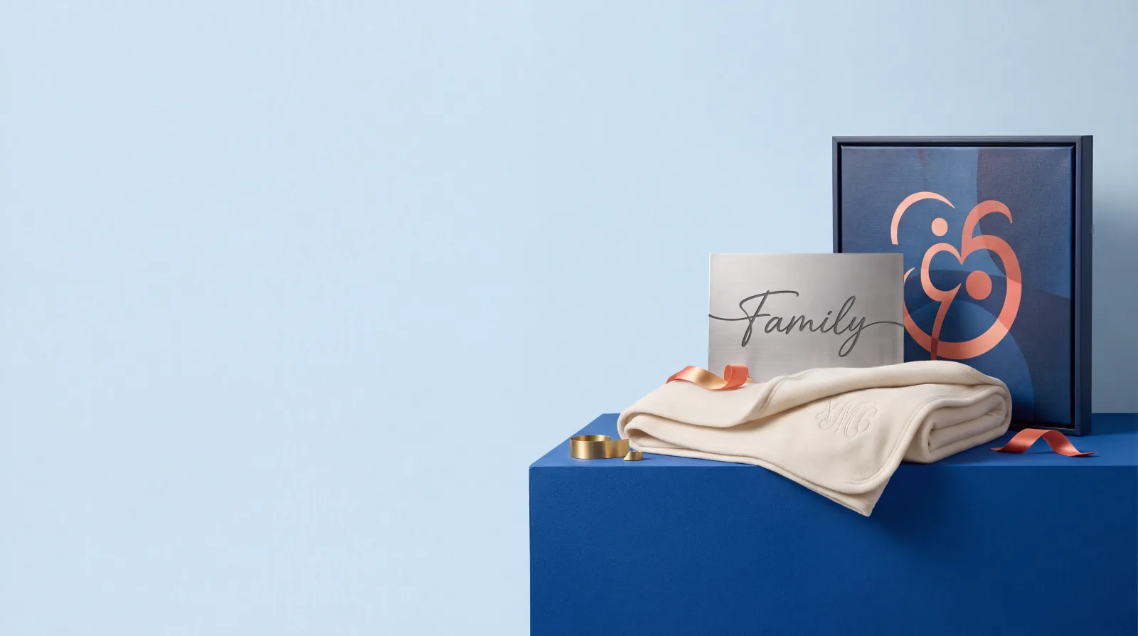 Personalized canvas, blanket and family sign arranged in a blue editorial gift setting