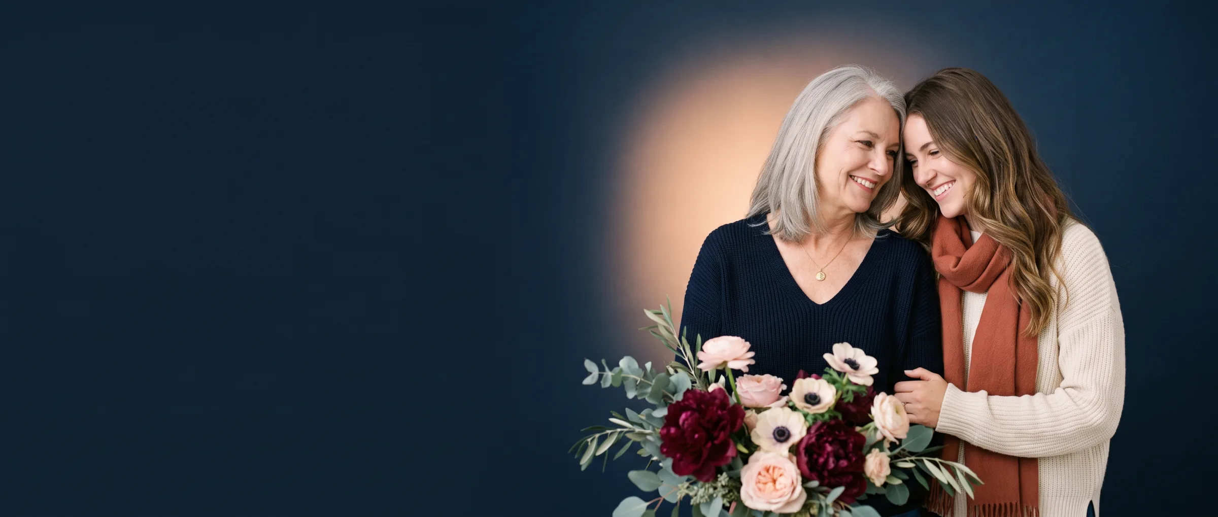 A mother and daughter sharing a warm moment beside a bouquet of peonies